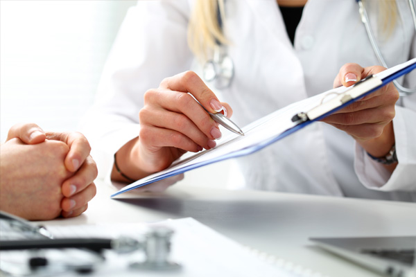 A nurse holding a clipboard and a doctor discussing 329 Card.