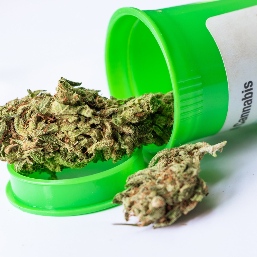 A close up of a medical cannabis flower in a green container.