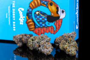 a box of cookies next to a pair of marijuana buds.