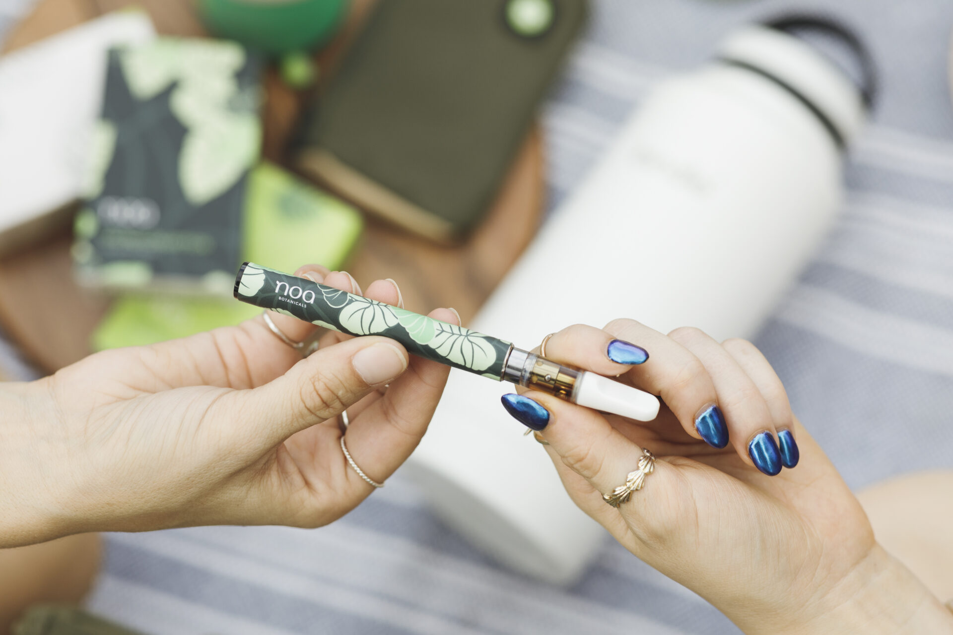 Two individuals engaging in medical cannabis consumption using a CBD vape pen.
