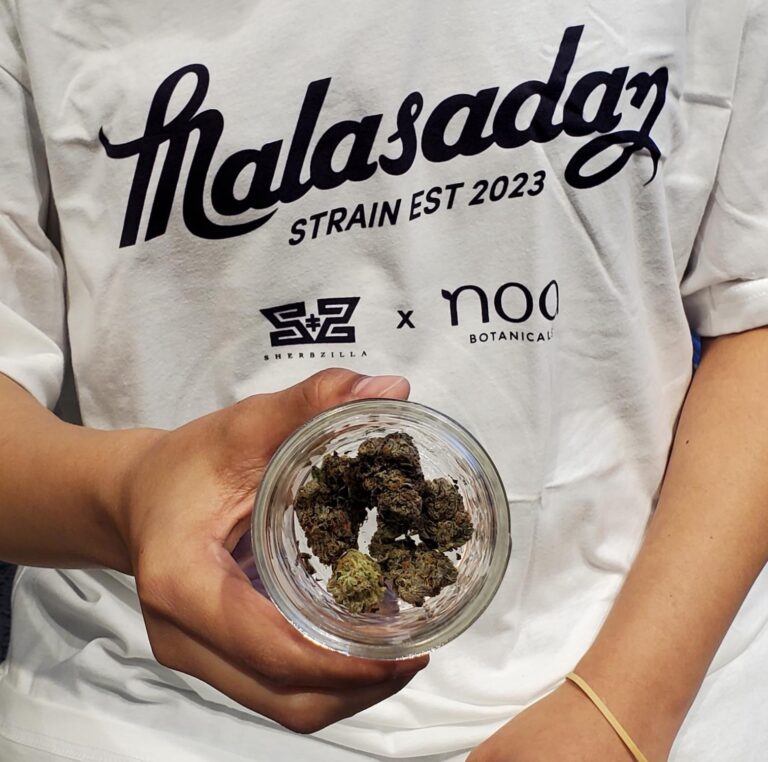 A person holding a jar of marijuana.