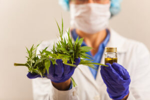 A woman in a lab coat is holding a bottle of cbd oil.